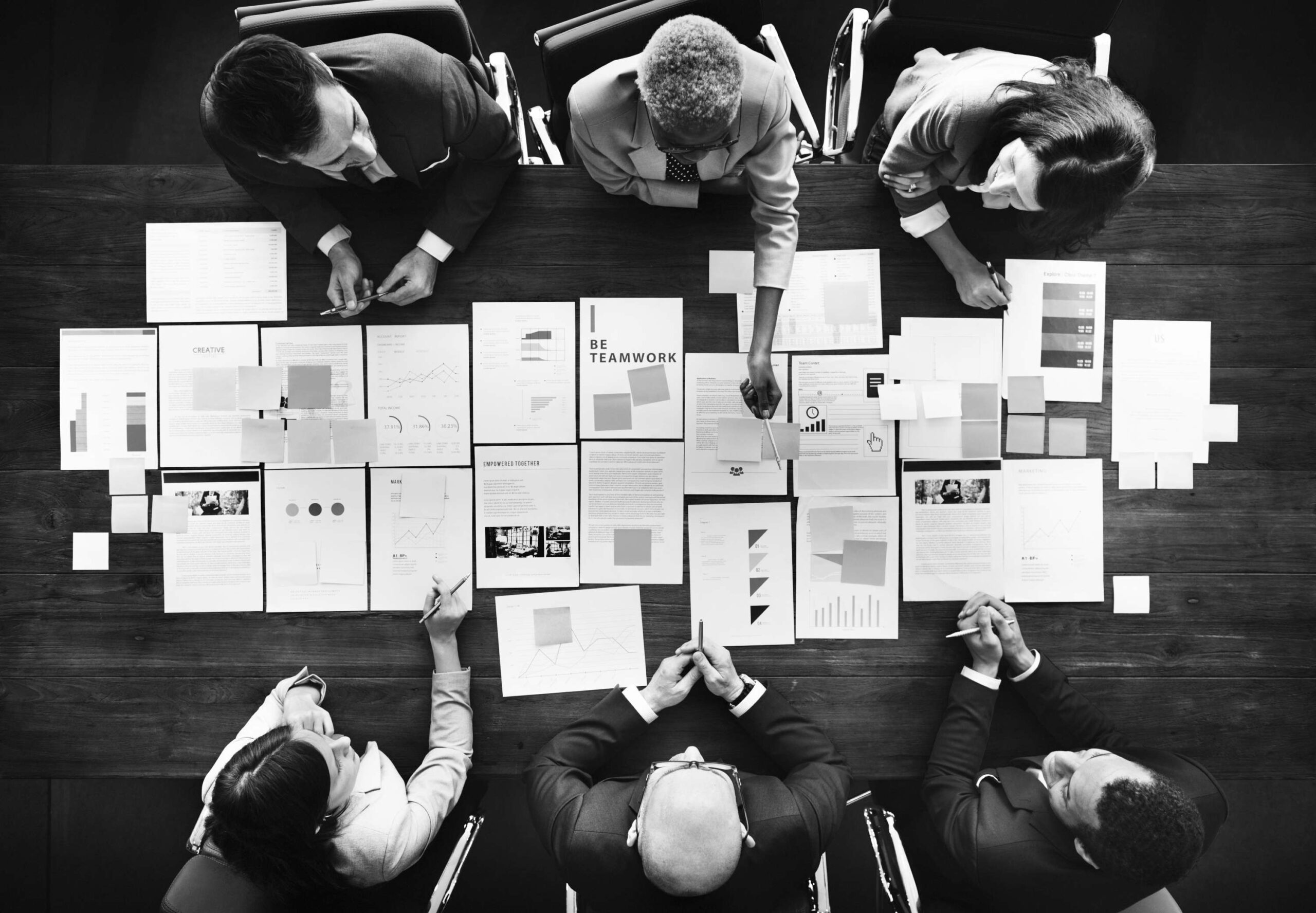 Grayscale photo of employees having a meeting